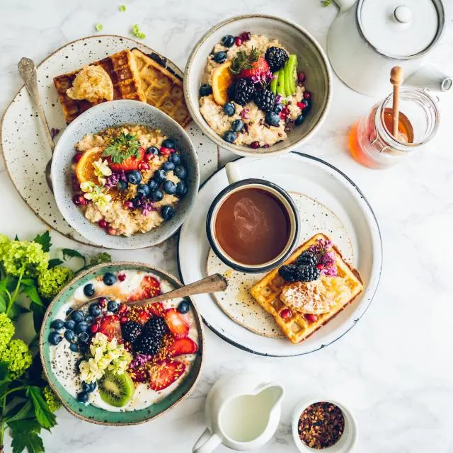 Mesa de café da manhã com frutas, iogurte e granola